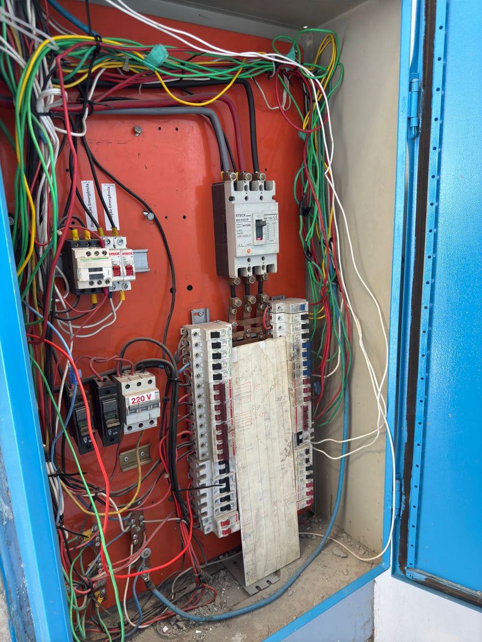 Quadro de distribuição com fiação desorganizada e sem proteção contra contatos